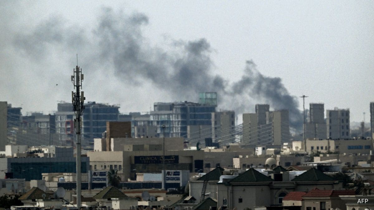 A plume of smoke rises over buildings in Doha