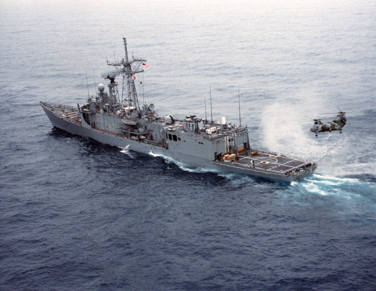 USS Samuel B. Roberts (FFG-58) underway after the ship struck a mine on April 14, 1988. A USMC CH-46 Sea Knight helicopter is on the helicopter pad.
