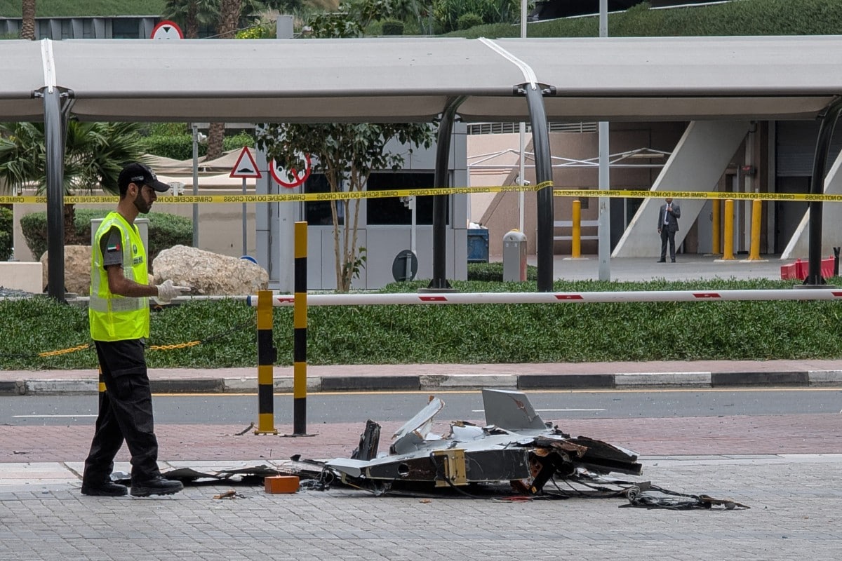 A policeman inspects the wreckage of a drone in downtown Dubai on March 12, 2026.