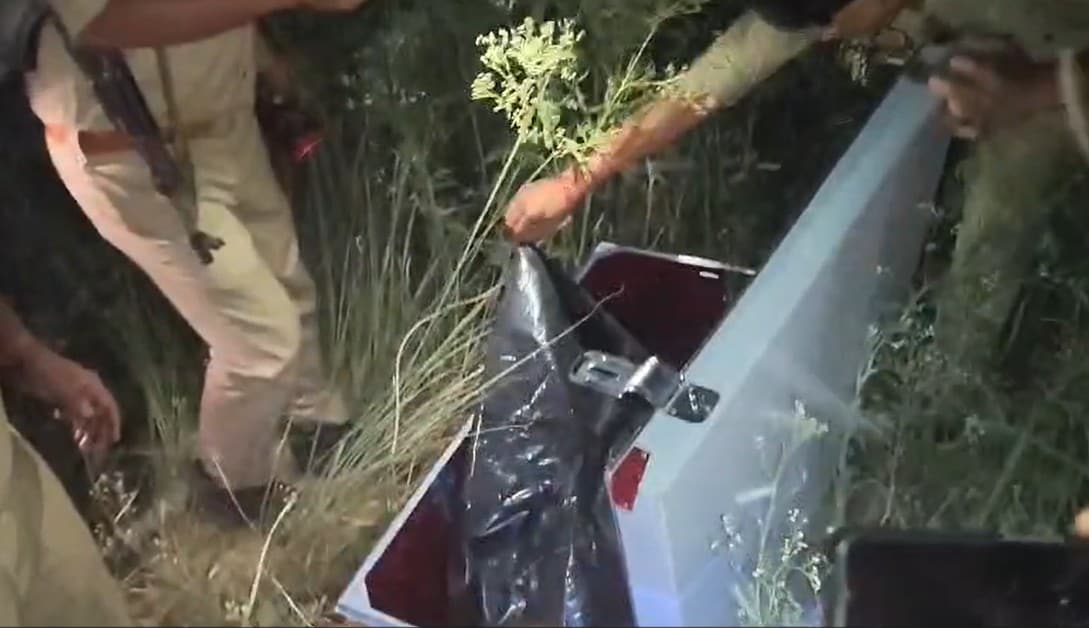 झाड़ियों में मिली संदिग्ध संदूक को खोलती हुई पुलिस की टीम