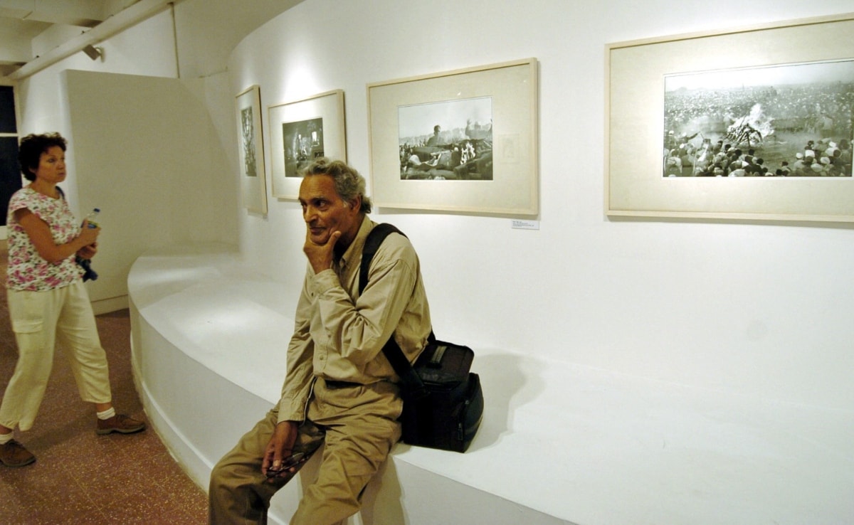 अपने चित्रों की एक प्रदर्शनी में बैठे फोटोग्राफर रघु राय.