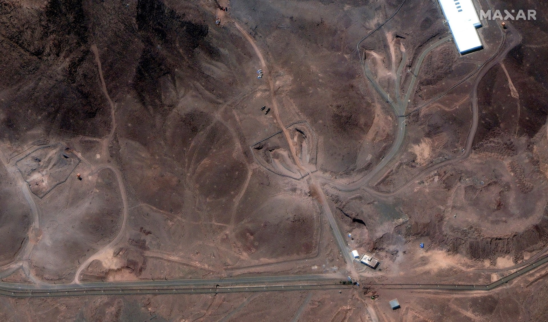 This handout satellite image provided by Maxar Technologies and dated June 29, 2025 shows a view of tunnel entrances at the Fordo (Fordow) Fuel Enrichment Plant complex, about 30 kilometres north of Qom in central Iran. (Photo by Satellite image ©2025 Maxar Technologies / AFP)