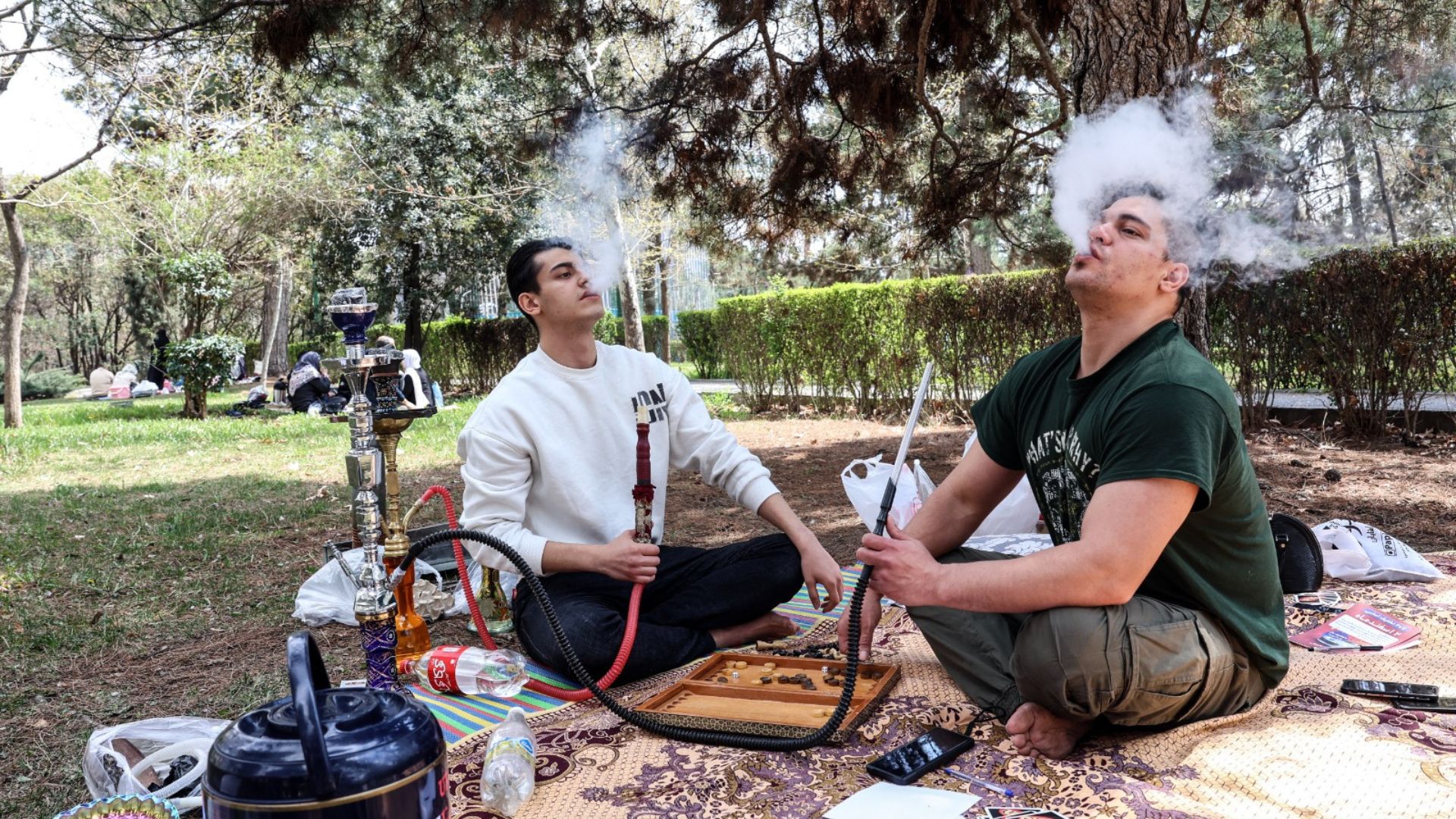 ट्रंप की धमकी को धुएं में उड़ा रहे ईरान के लोग, युद्ध के बीच तेहरान के पार्क में हुक्का पार्टी-Photos