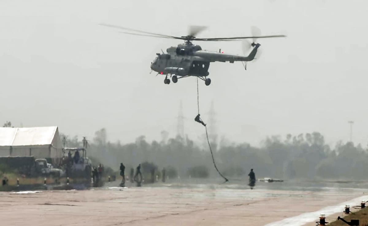 A troop slithering down a helicopter on the expressway.