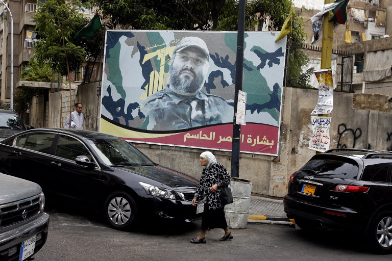 A Lebanese woman walks past a billboard bearing a portrait of Lebanese Hezbollah military leader, Imad Mughniyeh, in Beirut on September 26, 2008.
