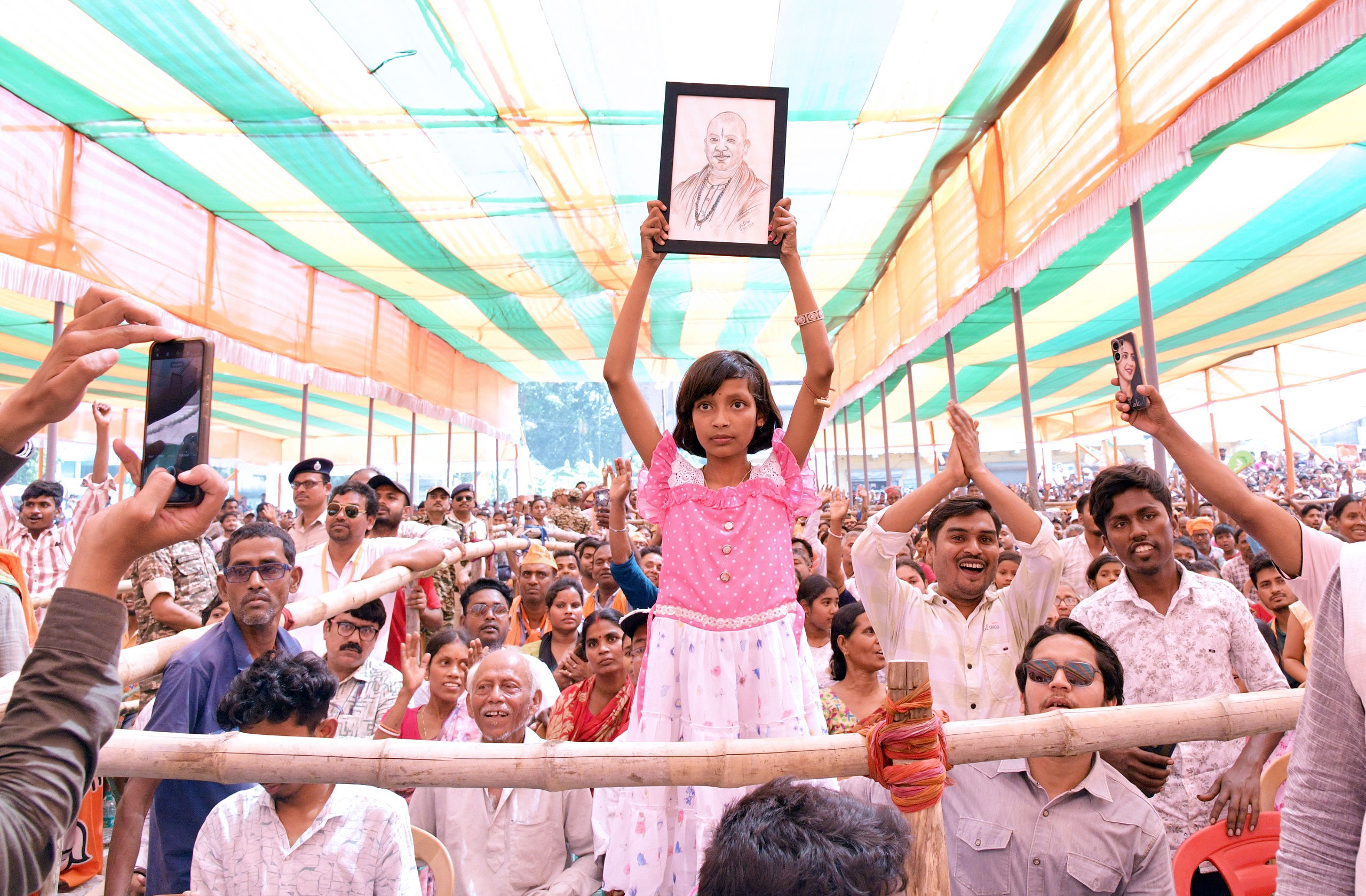 बंगाल में योगी की रैली में मौजूद लोगों की भीड़ से उनकी तस्वीर दिखाती एक बच्ची.