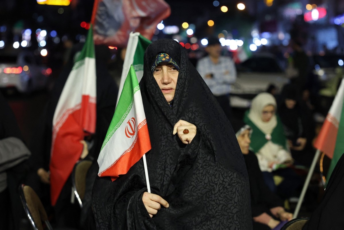 A woman holds an Irans national flag during an anti-US and Israel protest in Tehran