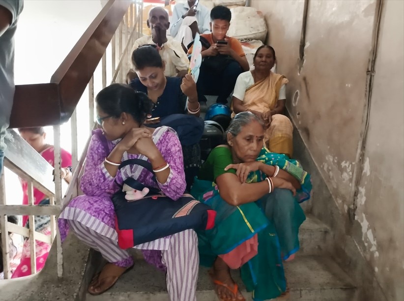 People waiting on staircase steps for a hearing at the CAA verification centre People waiting on staircase steps for a hearing at the CAA verification centre