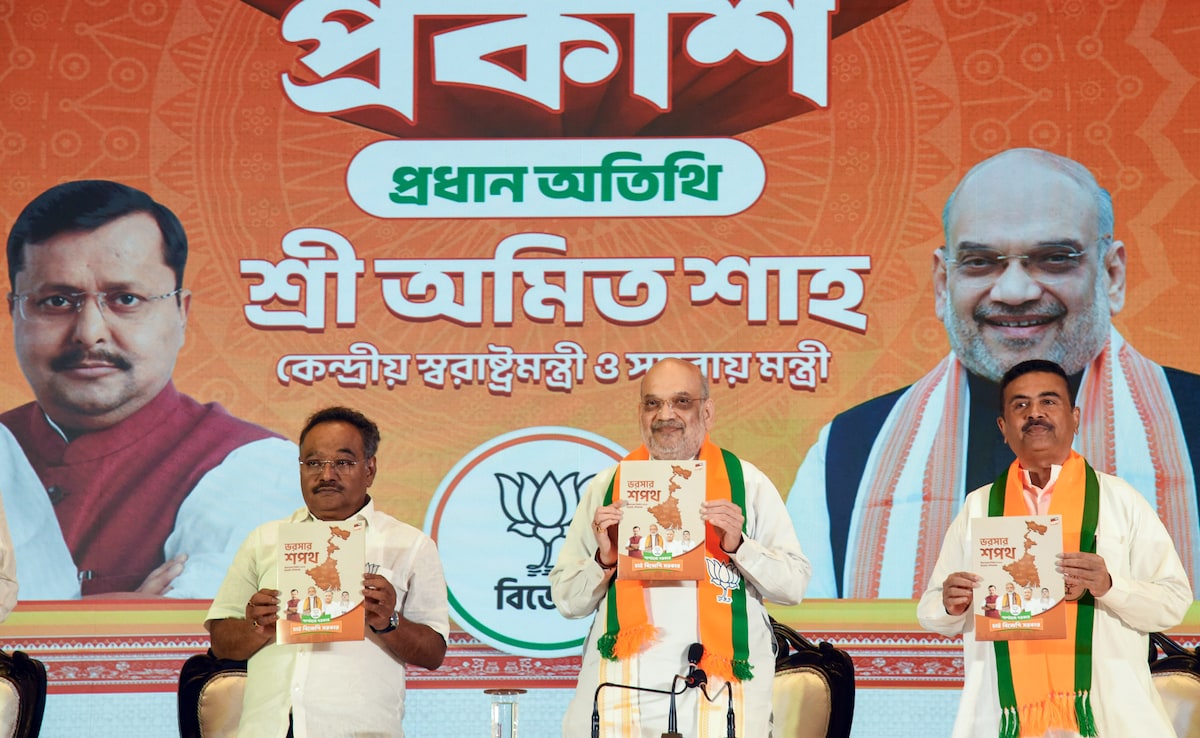 Union Home Minister Amit Shah (centre), BJPs Bengal President Samik Bhattacharya (left) and Suvendu Adhikari launch the BJPs manifesto on April 10, 2026