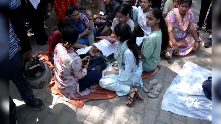 CUET UG 2026: चिलचिलाती धूप में फुटपाथ पर बैठे परीक्षार्थी, रोते हुए बोली छात्रा- "इस माहौल में कोई अच्छा परफॉर्म कैसे करे?"