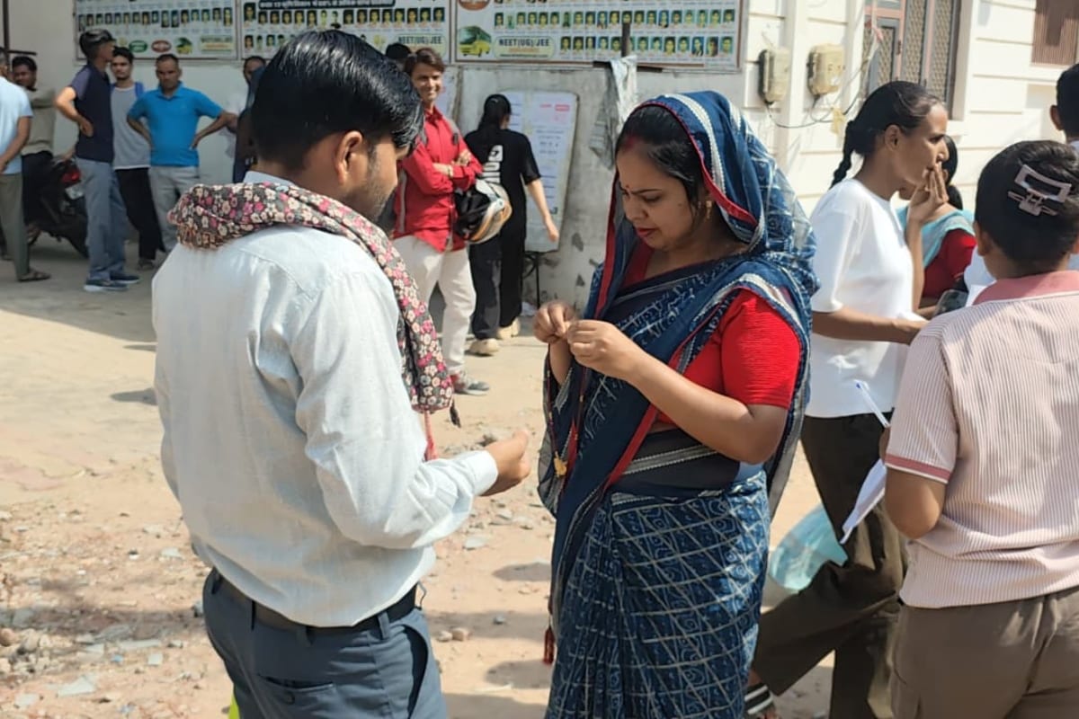 Lab Assistant Exam: कानों के टॉप्स उतारती महिला.