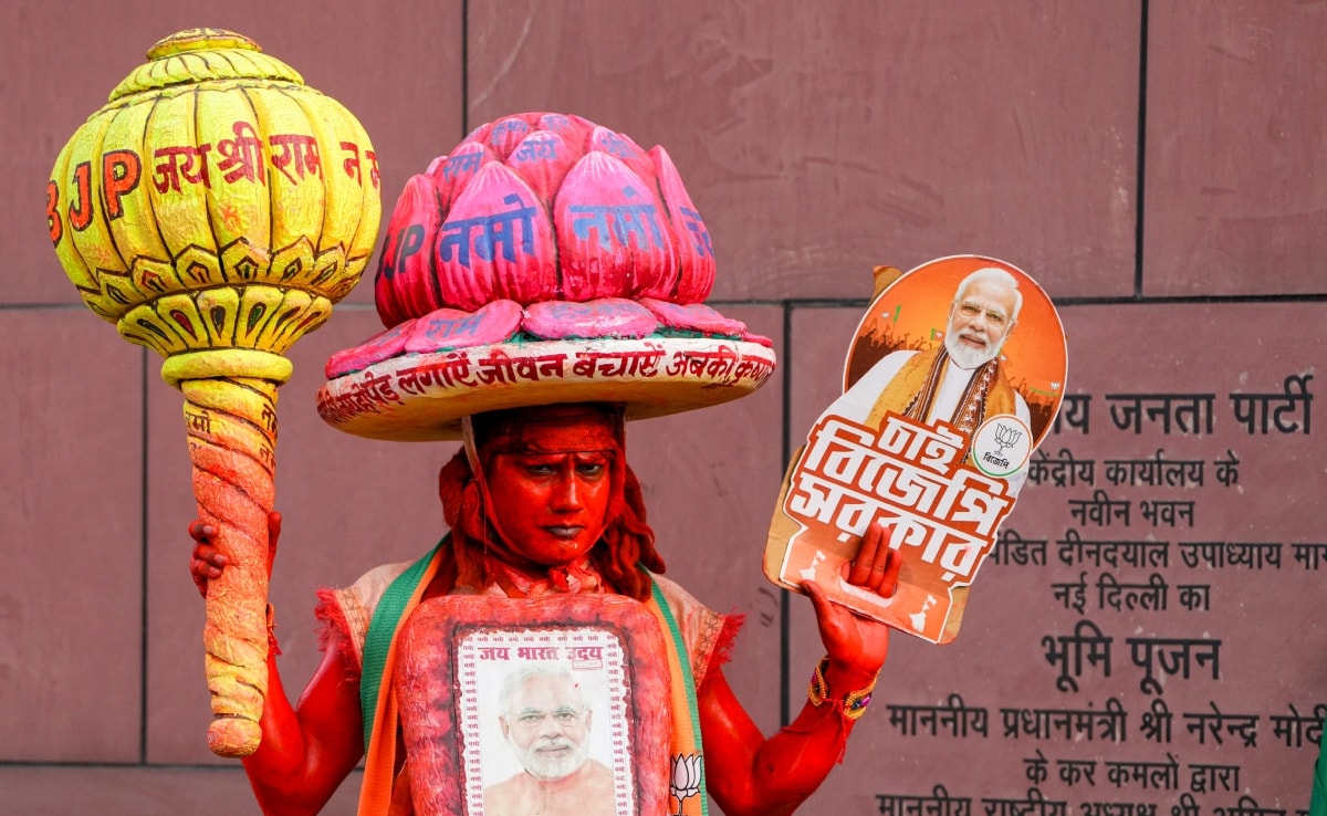 दिल्ली में बीजेपी के राष्ट्रीय मुख्यालय में पश्चिम बंगाल और असम में मिली पार्टी की जीत का जश्न मनाती एक महिला कार्यकर्ता.