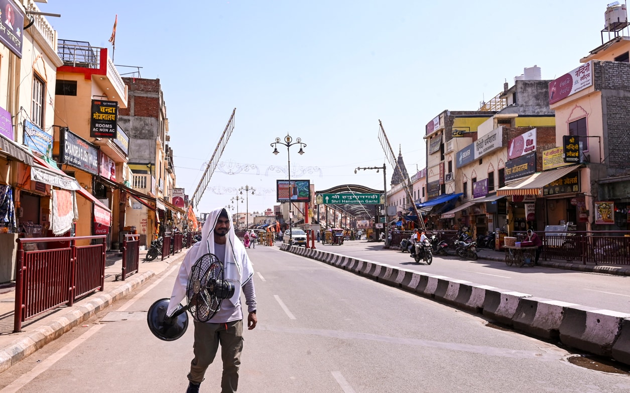 अयोध्या में हनुमानगढ़ी मंदिर के पास भीषण गर्मी के बीच एक व्यक्ति सड़क पर पंखा लेकर चल रहा है. अयोध्या में हनुमानगढ़ी मंदिर के पास भीषण गर्मी के बीच एक व्यक्ति सड़क पर पंखा लेकर चल रहा है.