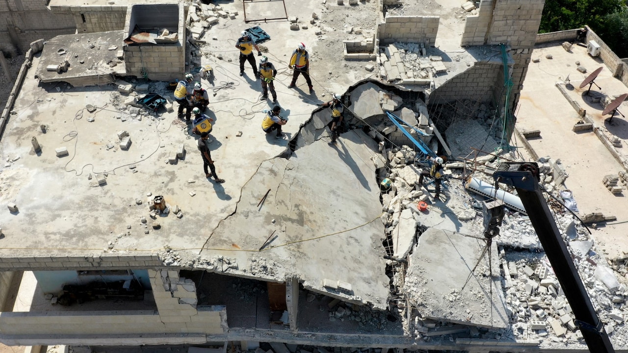 This picture taken on June 11, 2023, shows a White Helmets Civil Defence excavator removing debris from a building, damaged in the February 6 earthquake, in the town of Armanaz, in the northwestern part of Syrias Idlib province. (Photo by Omar HAJ KADOUR / AFP)