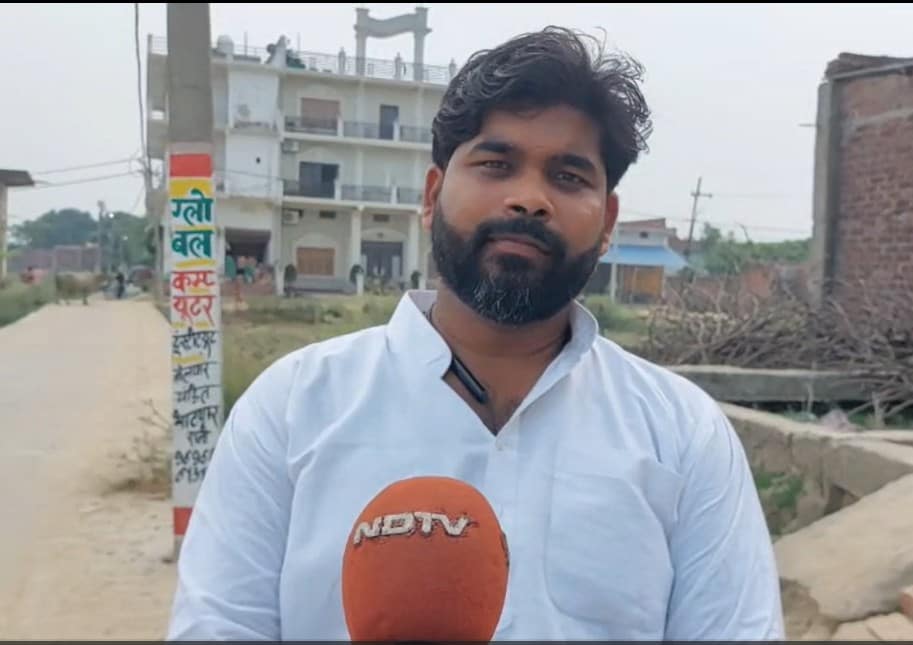 गांव में खान सर के घर के सामने उनके बारे में बताते स्थानीय सभासद आदित्य सिंह.