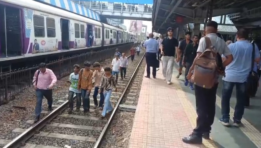 लोकल ट्रेन से उतर ट्रैक पर चलते लोग. लोकल ट्रेन से उतर ट्रैक पर चलते लोग.