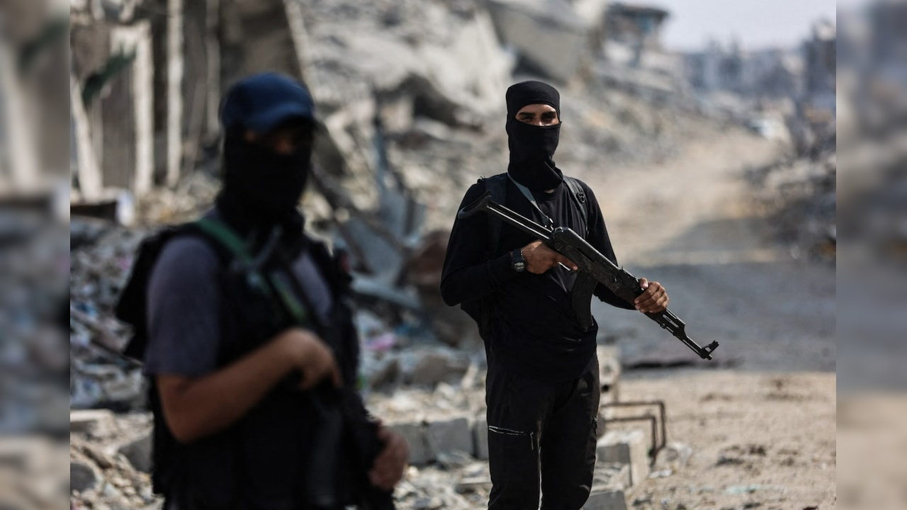 Hamas militants guard an area where they are searching for the bodies of hostages with the help of the ICRC in Gaza City. Hamas militants guard an area where they are searching for the bodies of hostages with the help of the ICRC in Gaza City.