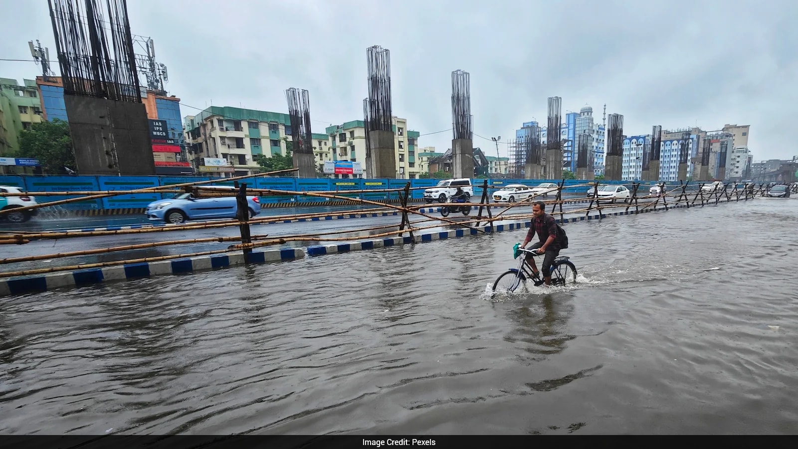 Doctor Pushes Bicycle Through Floodwater to Reach Patients