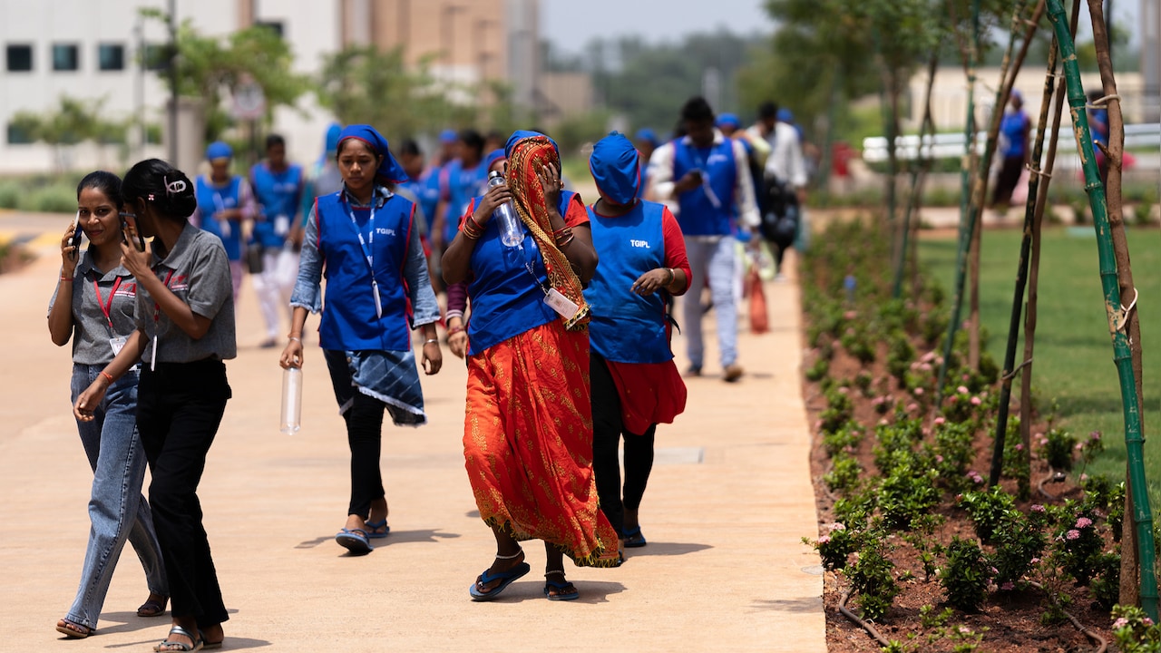 Workers shield their faces from the sun as they walk to their shift at a garment factory in India amid extreme summer heat Workers shield their faces from the sun as they walk to their shift at a garment factory in India amid extreme summer heat