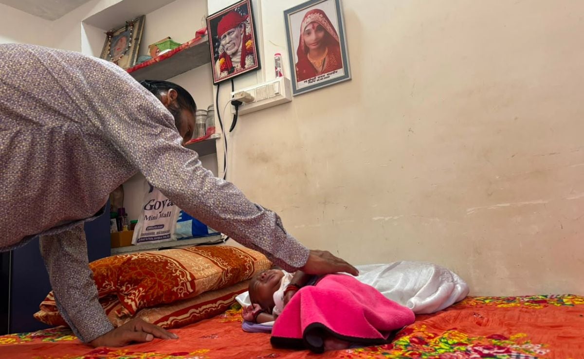 Pawan Malviya tries to soothe his newborn. Payal's photo hangs on the wall. Pawan Malviya tries to soothe his newborn. Payal's photo hangs on the wall.