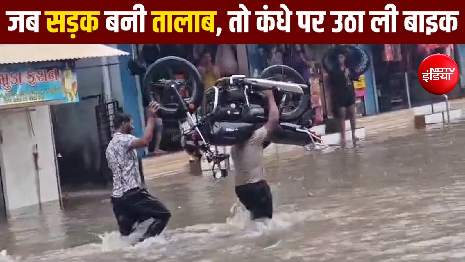 गुजरात में भारी बारिश के बीच 'बाहुबली' बना युवक, कंधे पर उठाई मोटरसाइकिल