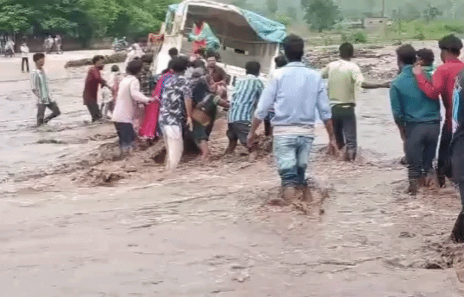VIDEO: बाढ़ में फंसा यात्रियों से भरा वाहन, ग्रामीणों ने ह्यूमन चेन बनाकर 25 लोगों का किया रेस्क्यू