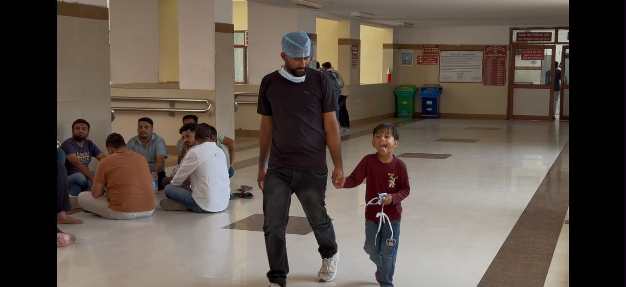 Sumer walks with his five-year-old son outside the ICU at AIIMS Jodhpur.