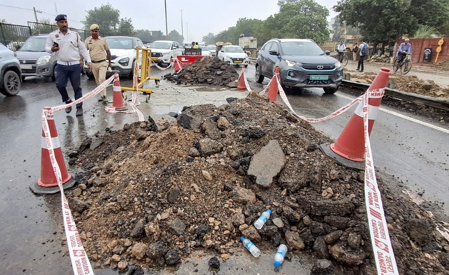 Police personnel inspect and secure the caved-in section of the Jaipur-bound carriageway on the Delhi-Gurugram Expressway (NH-48) near Narsinghpur Police personnel inspect and secure the caved-in section of the Jaipur-bound carriageway on the Delhi-Gurugram Expressway (NH-48) near Narsinghpur