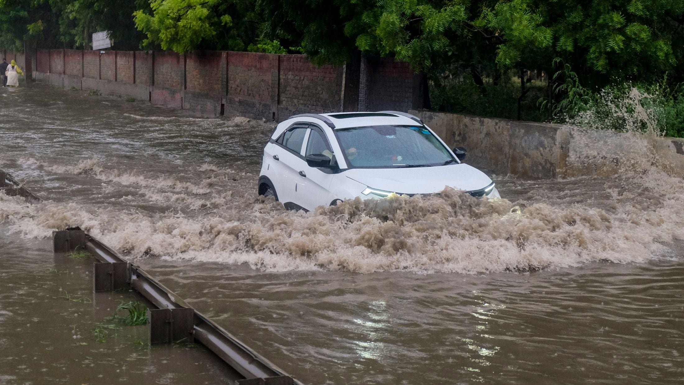 गुरुग्राम में बारिश के बाद जलभराव में फंसी कार