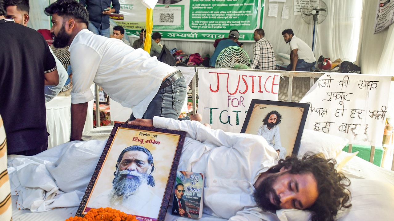 Student leader Divendranath Mahato sits on a hunger strike to protest the alleged JPSC examination paper leak, with a framed photograph of late Shibu Soren as a symbol of justice on his death anniversary, at Jaipal Singh Stadium in Ranchi on August 4