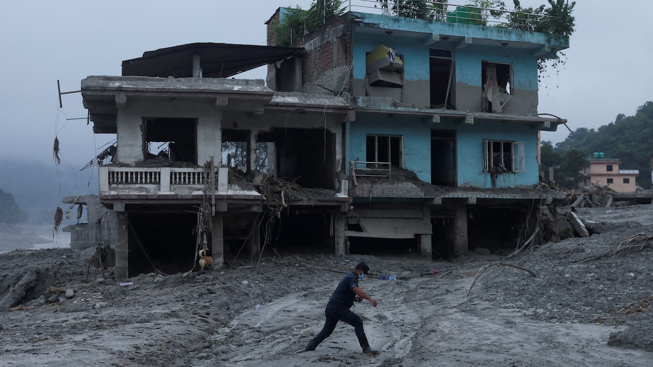 A man walks past a damaged house after the flash floods and mudslide in Nuwakot in Nepal