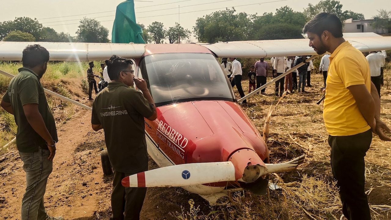 Security officials conduct a rescue operation after a trainer aircraft operated by a private company crash-lands at Baramati