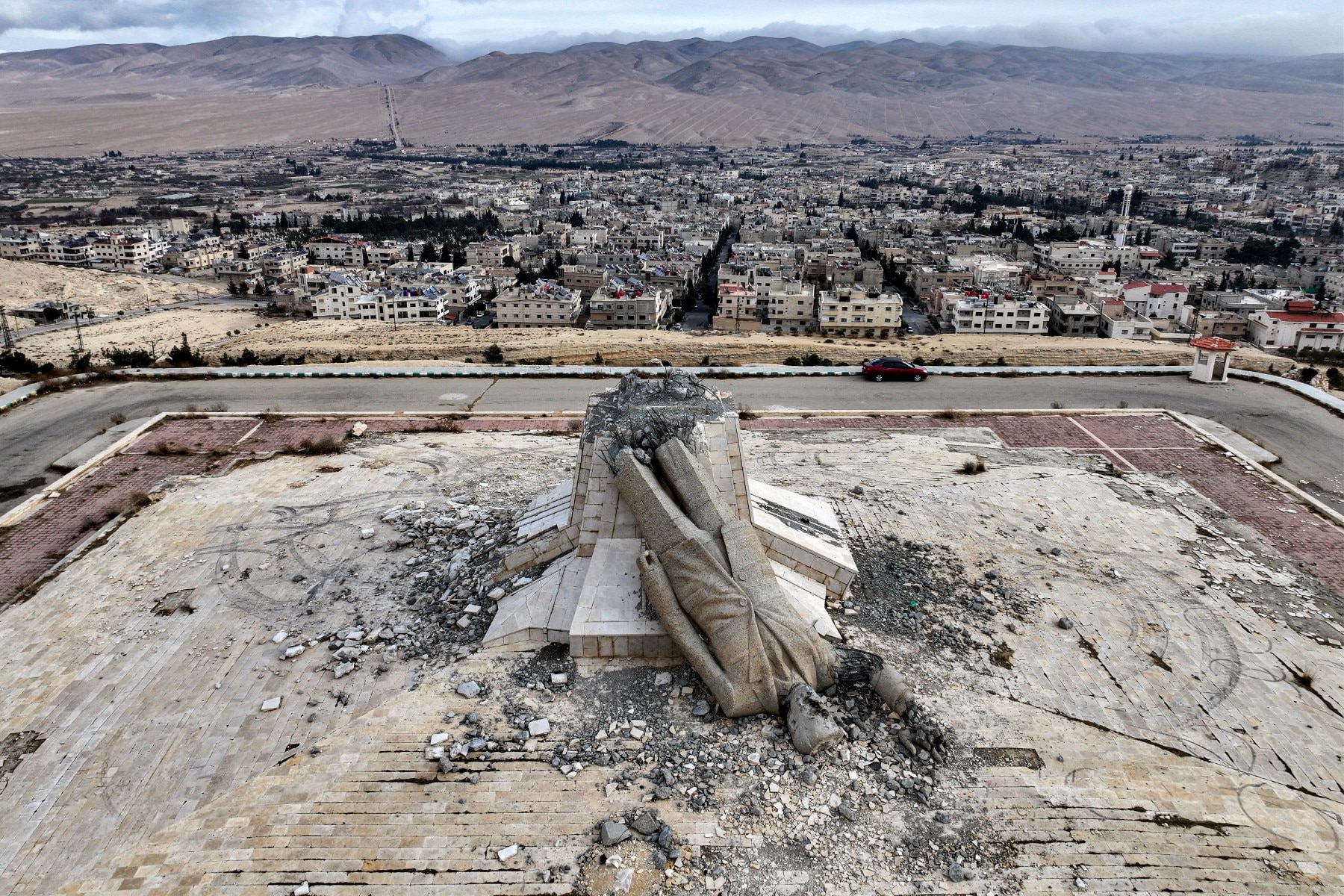 This aerial view shows the remains of a destroyed monument to Syrias late president Hafez al-Assad, father of ousted president Bashar al-Assad who died in 2000, in Deir Attiyah in the countryside of Damascus on December 28, 2024. This aerial view shows the remains of a destroyed monument to Syrias late president Hafez al-Assad, father of ousted president Bashar al-Assad who died in 2000, in Deir Attiyah in the countryside of Damascus on December 28, 2024.