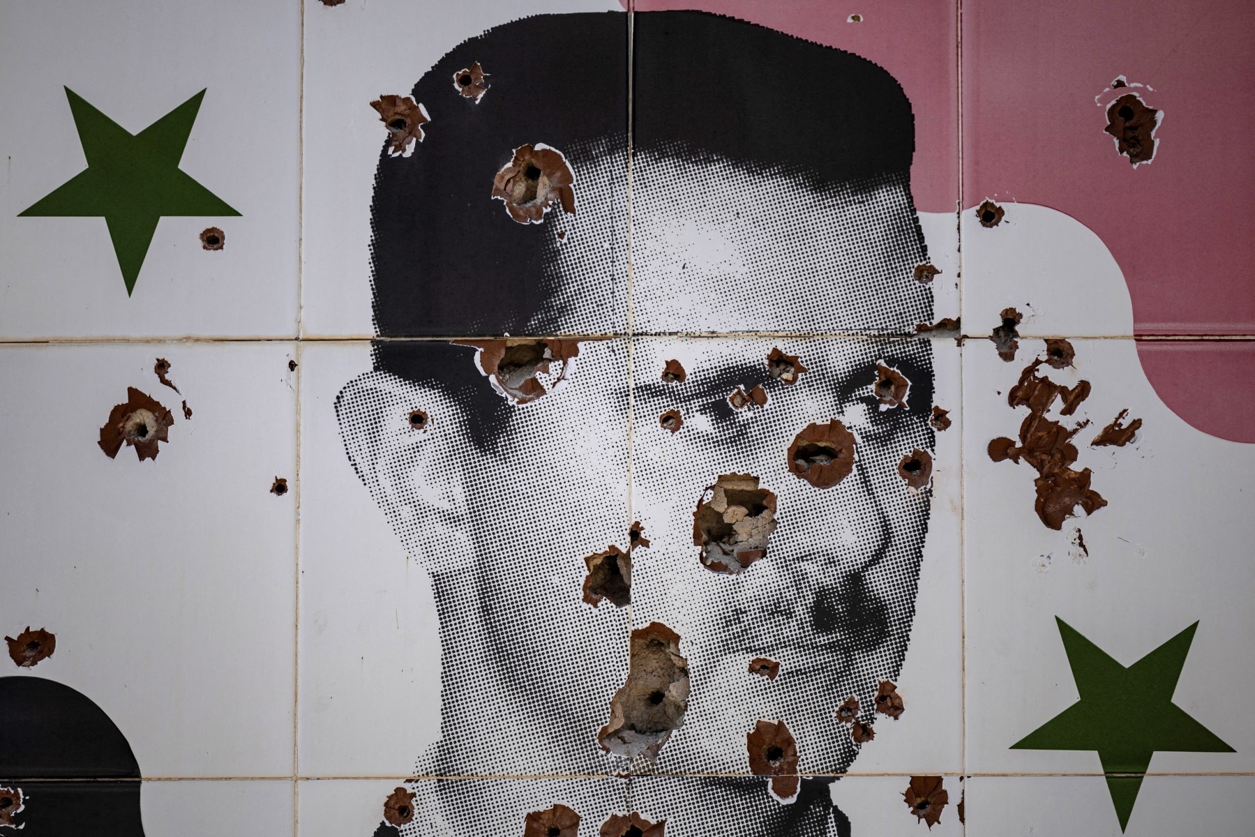 Bullet holes deface a mural depicting the toppled Syrian president Bashar al-Assad in Adra town on the northeastern outskirts of Damascus. Bullet holes deface a mural depicting the toppled Syrian president Bashar al-Assad in Adra town on the northeastern outskirts of Damascus.