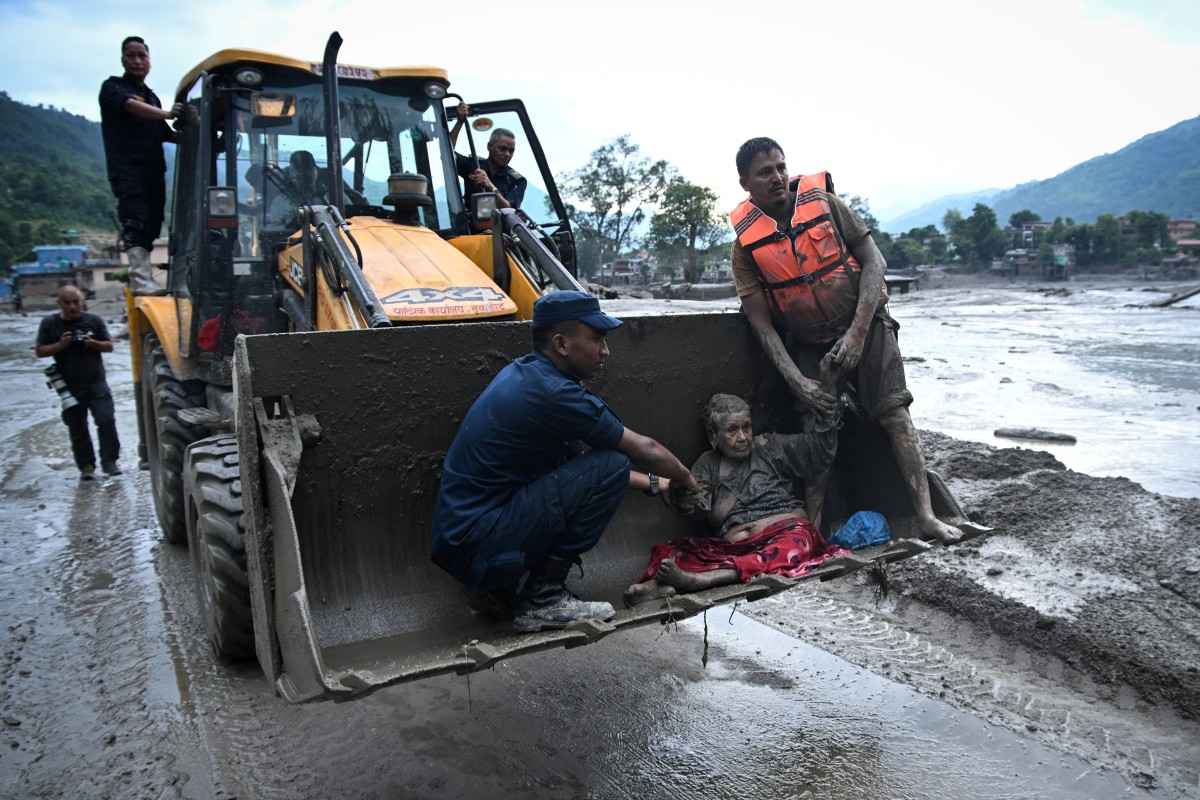 Rescuers use an excavator to transport a flood survivor in Nepal Rescuers use an excavator to transport a flood survivor in Nepal
