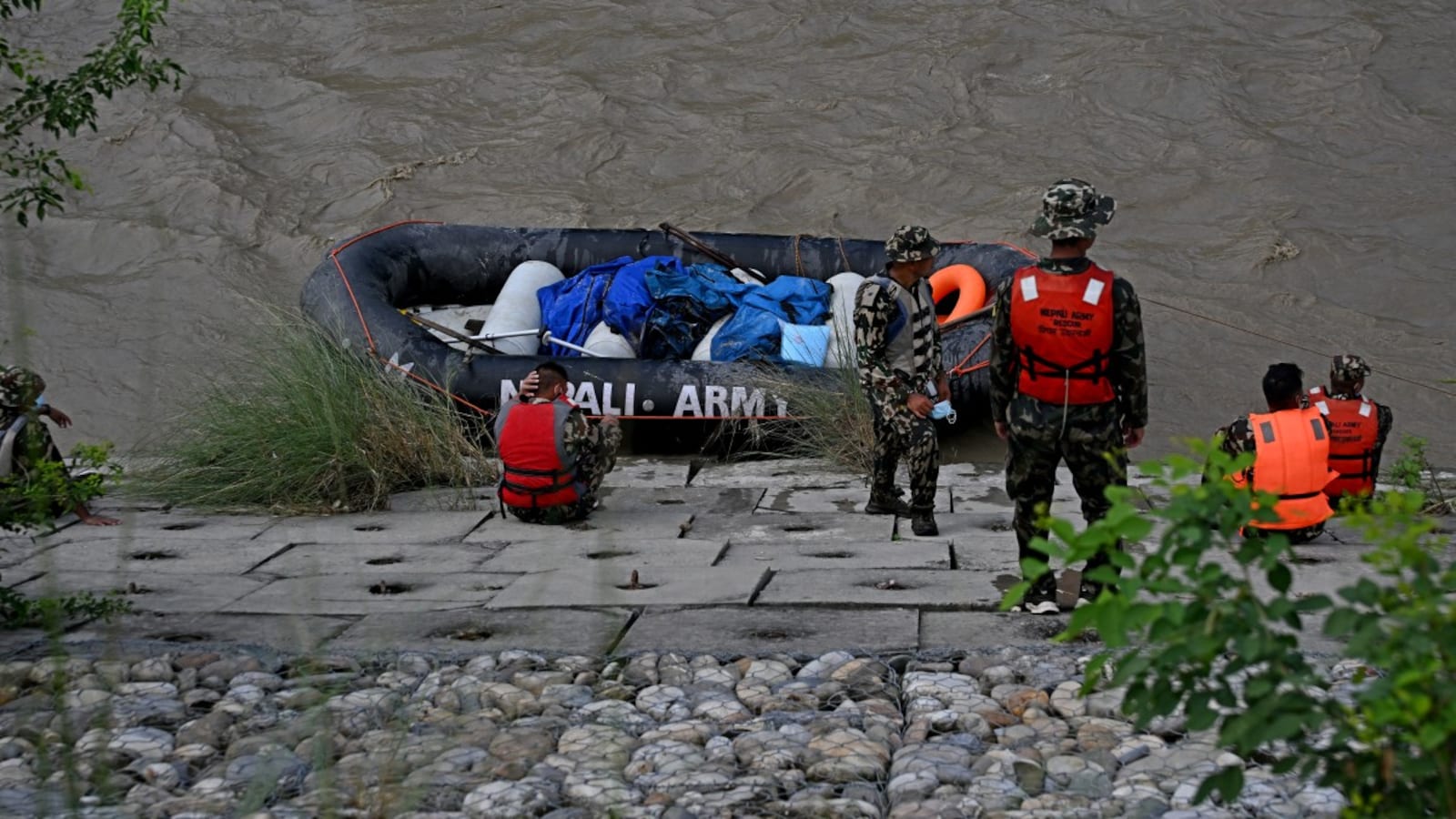 Nepal's army personnel carry bodies of flood victims along the Narayani river
