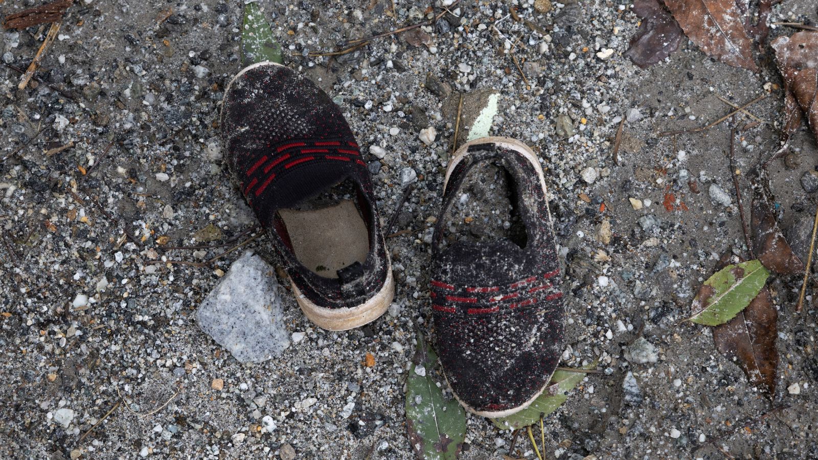 A pair of shoes belonging to a child, covered in sludge, lies on the grounds of Uttargaya Public School following flash floods and mudslides in Angitar, Nuwakot district, Nepal.