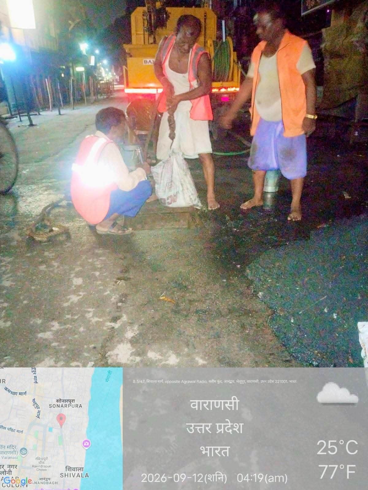 नालियों से बालू भरी बोरियां निकालते वाराणसी नगर निगम के कर्मी. 
