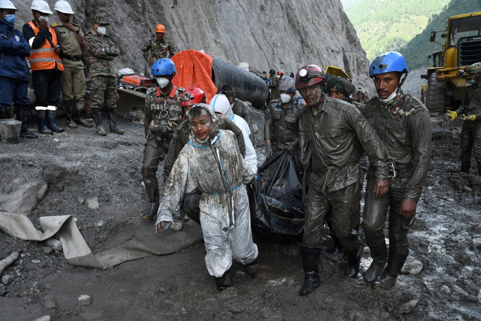 Members of a search and rescue teams carry the body of a victim from the inside the Chilime Hydropower Project tunnel