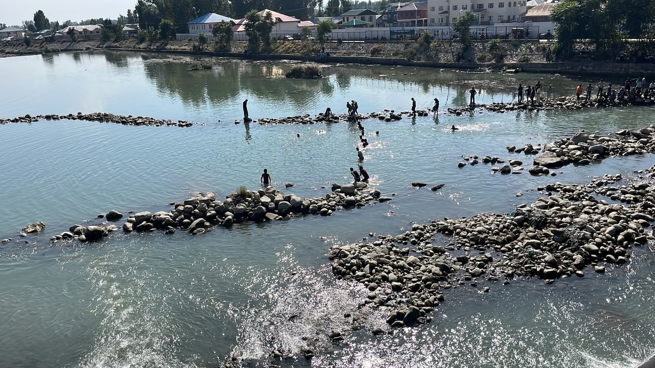Rescuers continue the search operation as villagers and passersby stand silently along the riverbank. Rescuers continue the search operation as villagers and passersby stand silently along the riverbank.
