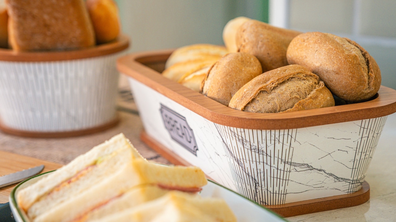 A fresh loaf of bread kept neatly inside a bread box on the kitchen counter A fresh loaf of bread kept neatly inside a bread box on the kitchen counter