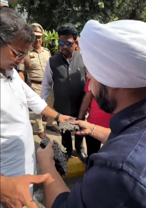 Jarnail Singh presents the pulled out road chunks to Parvesh Verma Jarnail Singh presents the pulled out road chunks to Parvesh Verma