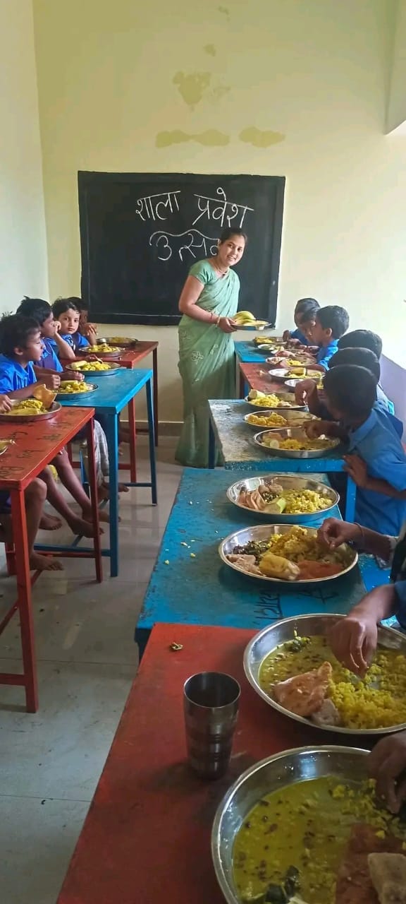 शाला में प्रवेश उत्सव के दौरान भोजन करते हुए बच्चे
