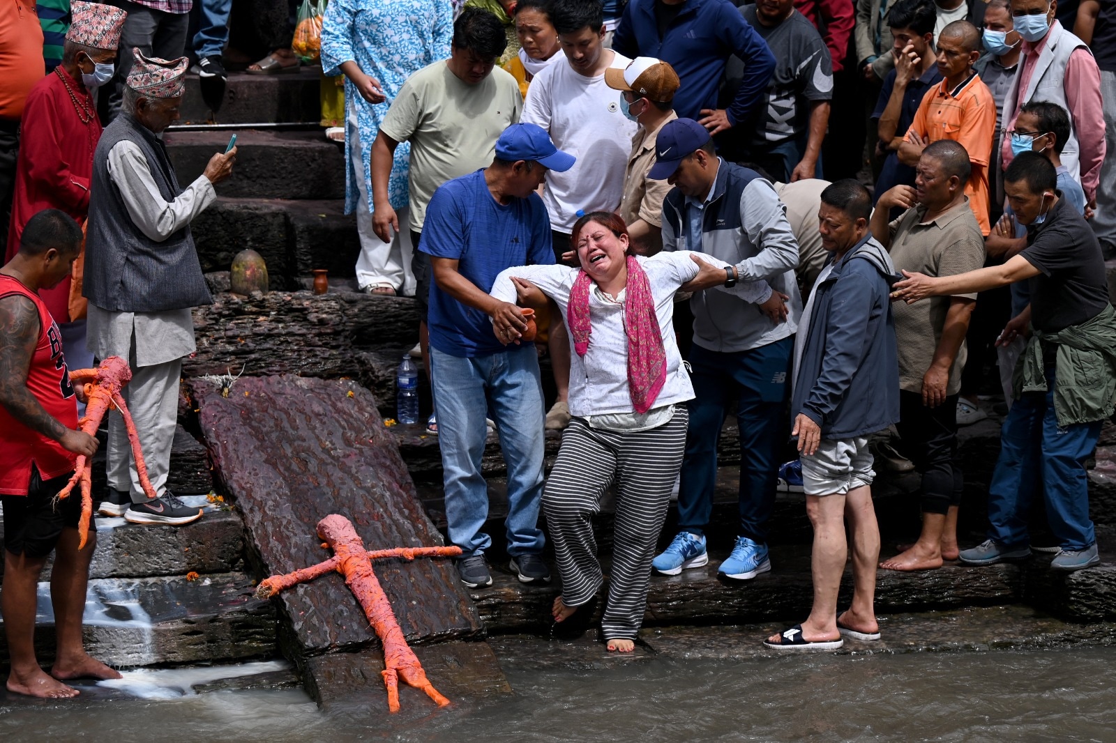 काठमांडू के पशुपतिनाथ मंदिर में, बाढ़ में लापता लोगों के लिए प्रतीकात्मक अंतिम संस्कार के दौरान रिश्तेदार शोक मना रहे हैं. वे नेपाली हिंदू रीति-रिवाजों के अनुसार कुश घास से बने पुतलों का अंतिम संस्कार कर रहे हैं. (फोटो- एएफपी) काठमांडू के पशुपतिनाथ मंदिर में, बाढ़ में लापता लोगों के लिए प्रतीकात्मक अंतिम संस्कार के दौरान रिश्तेदार शोक मना रहे हैं. वे नेपाली हिंदू रीति-रिवाजों के अनुसार कुश घास से बने पुतलों का अंतिम संस्कार कर रहे हैं. (फोटो- एएफपी)