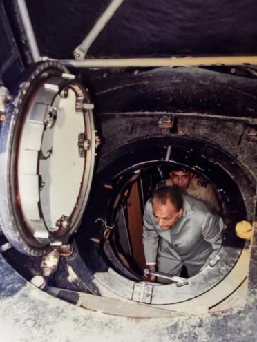 K.C. Pant climbs through a submarine hatch. 