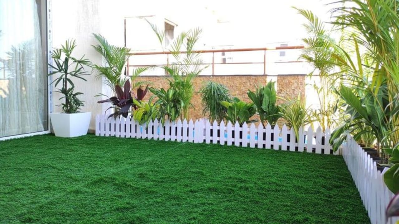 A balcony corner brightened up with a soft artificial grass mat underfoot A balcony corner brightened up with a soft artificial grass mat underfoot