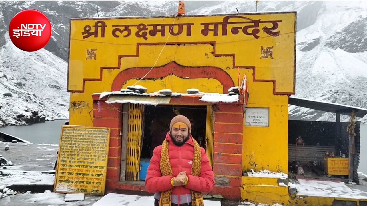 बर्फबारी के बीच मंदिर के सामने श्रद्धालु