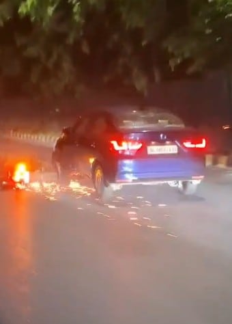 The elderly man seen dragging the motorbike under his car