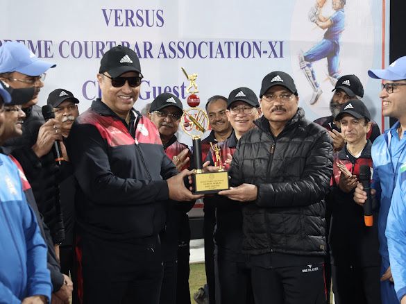 Justice Dipankar Datta receiving a trophy from CJI Surya Kant at a recent cricket tournament.