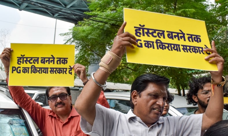 Protesters hold placards reading Government should pay PG rent until hostels are built during a demonstration near South Campus